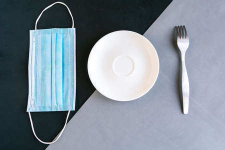 medical mask and empty plate on color background. Minimal concept.の写真素材