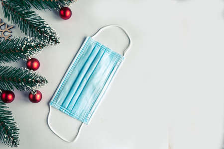 christmas tree branches and face mask on white background, coronavirus Christmas conceptの写真素材