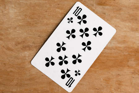 Ten of Club playing card, wooden background.の写真素材