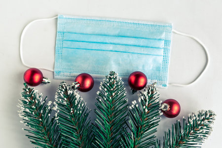 christmas tree branches and face mask on white background, coronavirus Christmas concept