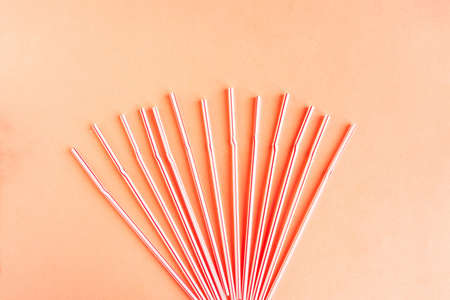 Plastic drinking cocktail straws on pink background, top view. Make a cocktail.の写真素材