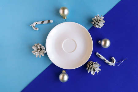 Empty plate and Christmas decoration on color geometric background, minimal concept, copy space for the textの写真素材