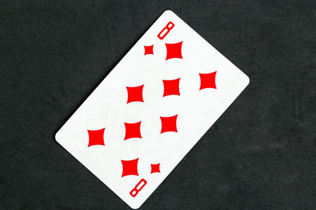 Eight of Diamonds playing card, black background.