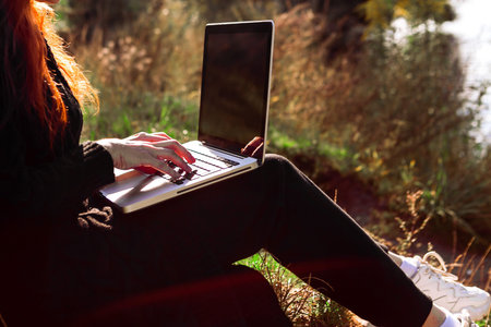 Freelancer in the nature. Woman is working on laptop in forest.の写真素材