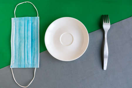 medical mask and empty plate on color background. Minimal concept.の写真素材