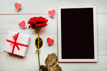 Red rose and gift box at wooden background, top viewの写真素材