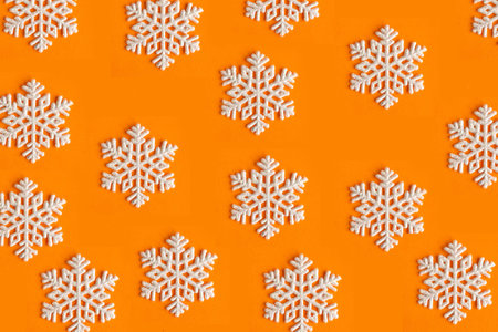 Snowflake pattern at bright orange background. Winter background. Christmas festive background.の写真素材