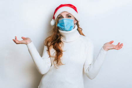 Portrait of woman in protective mask and Santa hat. Christmas with social distance. Coronavirus Christmas concept.の写真素材