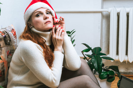 Portrait of young beautiful woman in Santa hat. Merry Christmas and Happy new year
