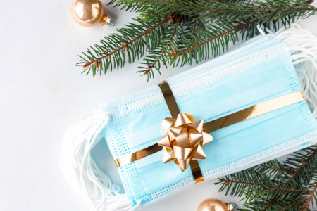 Christmas composition with hygienic face masks as a gift with a golden ribbon, top view. Coronavirus Christmas concept.の写真素材