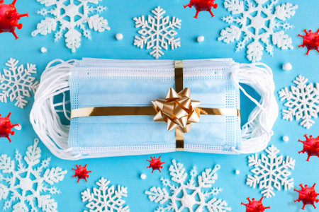 Hygienic face masks as a gift with a golden ribbon, top view. Coronavirus Christmas conceptの写真素材