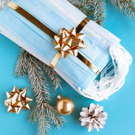 Hygienic face masks as a gift with a golden ribbon, top view. Coronavirus Christmas concept.の写真素材
