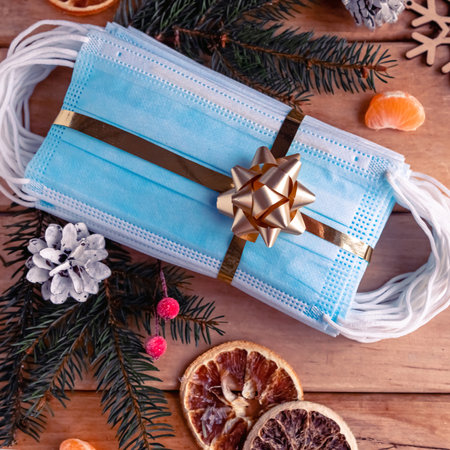 Hygienic face masks as a gift with a golden ribbon, top view. Coronavirus Christmas concept.の写真素材