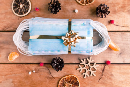 Hygienic face masks as a gift with a golden ribbon, top view. Coronavirus Christmas concept