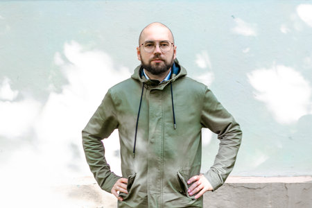 young guy with a beard and glasses is posing in the park, fashion man, outdoor portrait, close upの写真素材