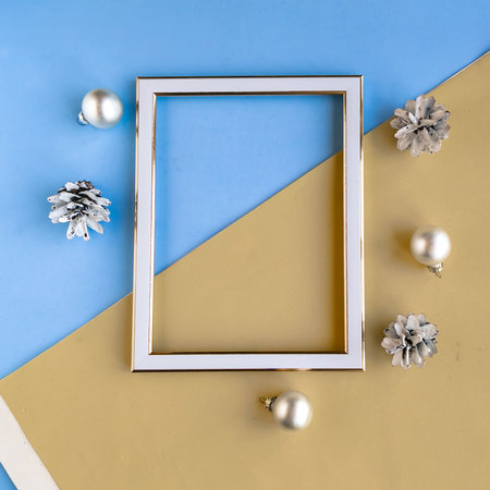 Photo frame and Christmas decorations on color geometric background, copy space for the text. Template for Christmas greeting cardの写真素材