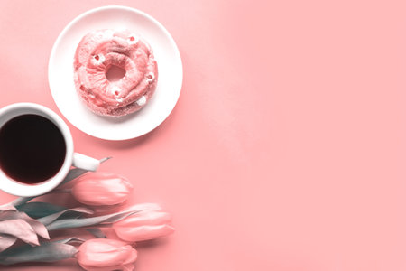 Bouquet of tulips, sweet donut and coffee cup on pink background, copy space for the text, toned...