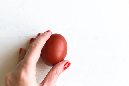 Woman holds red Easter egg in hand, close upの写真素材