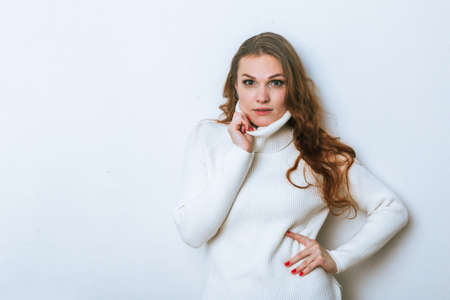 Portrait of ginger woman in white sweater in studio with isolated background.の写真素材