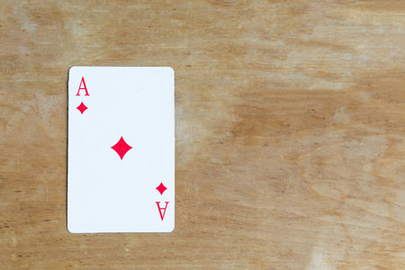 Ace of Diamonds playing card on wooden background, top view, copy space