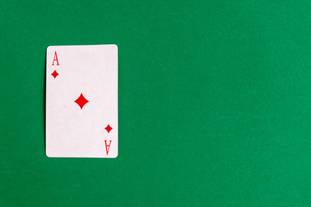Ace of Diamonds playing card on green background, top view, copy space