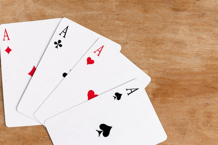 Poker quads playing card, wooden background