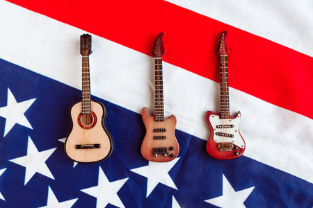 Acoustic, electric and bass guitar on American flag background. Minimal concept, top view