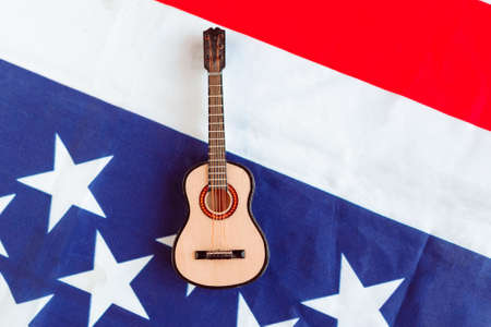 Acoustic guitar on American flag background. Minimal concept, top viewの写真素材