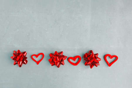 Red hearts and bows on blue background. Happy Valentine's Day. Minimal concept. Copy space for the textの写真素材