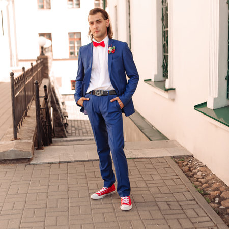 Portrait of a young handsome groom in a city street backgroundの写真素材