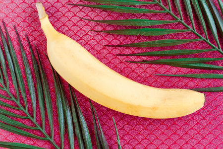 Fresh tasty banana on red background. Healthy food concept. minimal conceptの写真素材