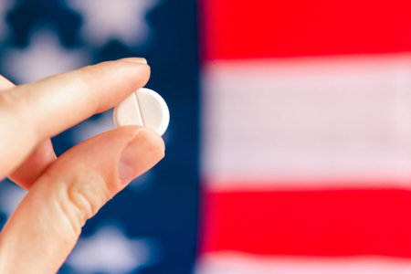 woman's hand holds a pill on American flag background