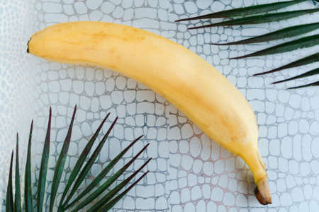 Fresh tasty banana on silver background. Healthy food concept. minimal conceptの写真素材