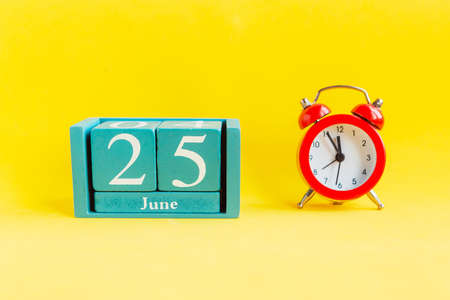 June 25. Blue cube calendar with month date on bright yellow backgroundの写真素材