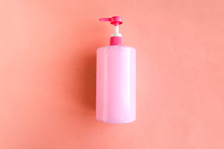 Bottle with pink dishwashing liquid on pink background. minimal conceptの写真素材