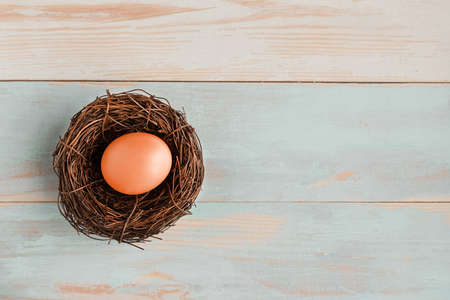 Chicken egg in the nest on wooden background. top view. copy spaceの写真素材