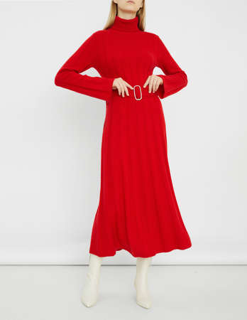 Woman in red dress and white boots in studio with white isolated background.の写真素材