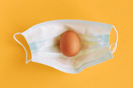 Chicken egg face medical mask. Easter holiday during the coronavirus pandemic