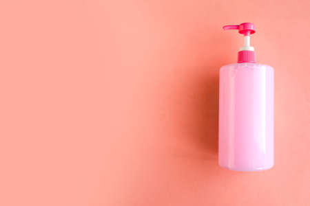 Bottle with pink dishwashing liquid on pink background. minimal concept. Copy space for the textの写真素材