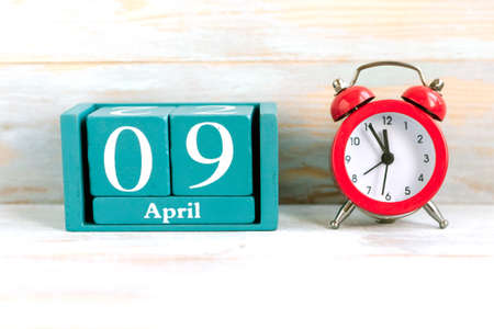April 9. Blue cube calendar with month and date on wooden background.の写真素材