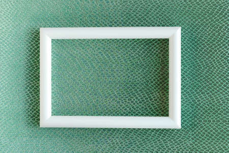 White photo frame on green background with crocodile pattern. minimal concept. Template for designの写真素材