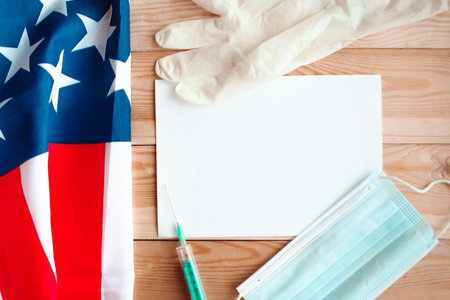 face medical masks and American flag on wooden background. virus in America concept. copy space