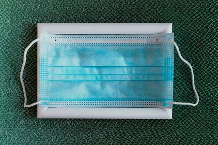 Face medical mask on color pattern background. Minimal concept