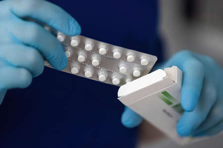 Hand in gloves takes the pills out of the packageの写真素材