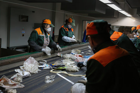 Minsk Belarus â€“ March 17 2021: Conveyor for sorting garbage waste by people. Garbage...