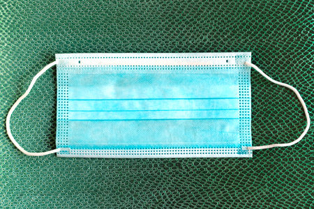 Face medical mask on color pattern background. Minimal concept