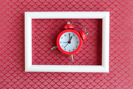 Alarm clock and white photo frame on color background. minimal conceptの写真素材