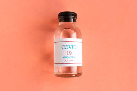 Coronavirus vaccine bottle on pink background. Minimal conceptの写真素材