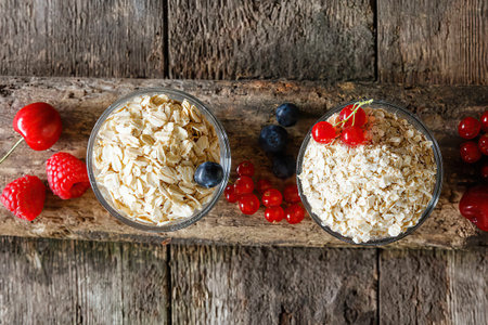 Various oat flakes and berries in a bowls, top view