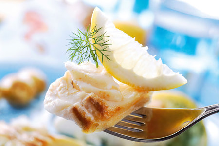 Codfish with dill and lemon slice on fork